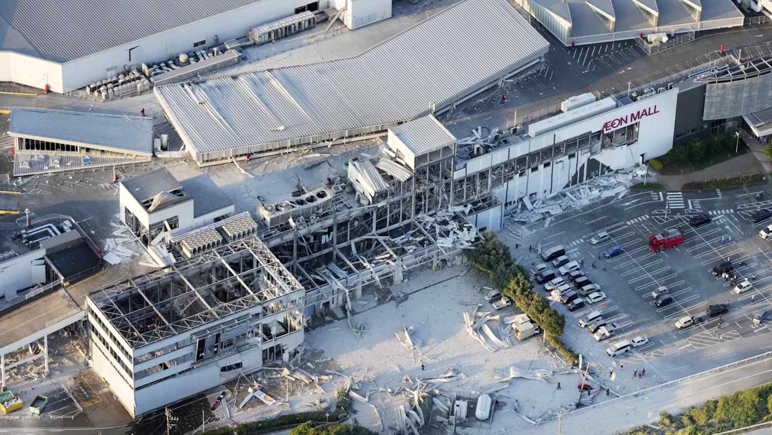 Aerial view of earthquake damage to an Aeon Mall shopping center in Kumamoto Prefecture, with collapsed sections and scattered debris