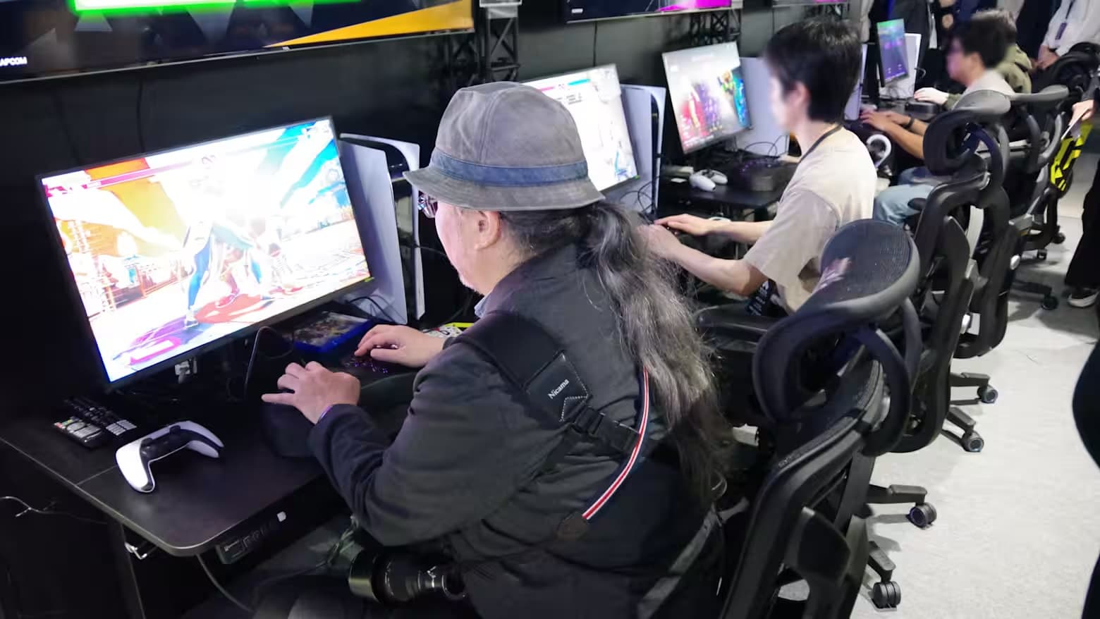 Competitors play a fighting game on ergonomic chairs at an esports event in Japan