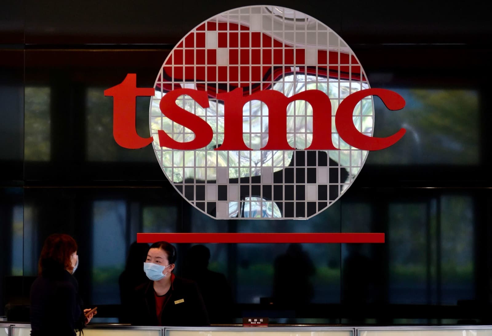 The TSMC logo on a silicon wafer display behind a reception desk