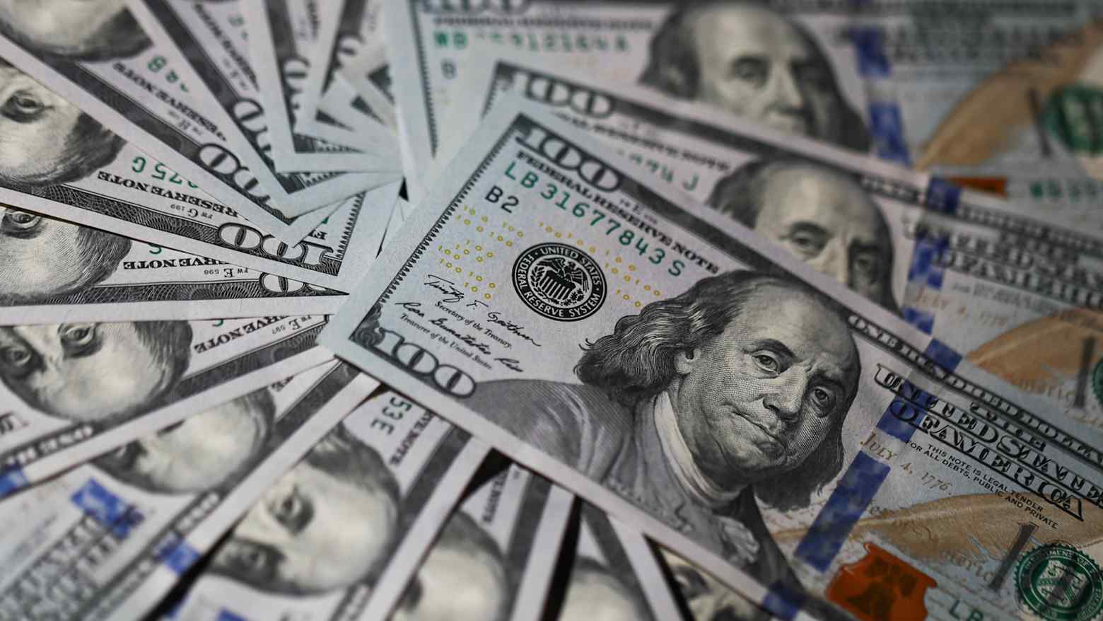 Fanned out one hundred US dollar bills featuring Benjamin Franklin