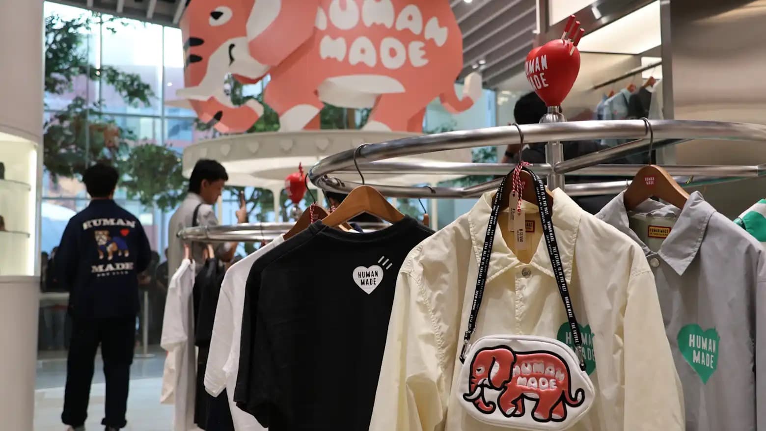 Human Made apparel and an elephant motif crossbody bag on a display rack at a Bangkok store