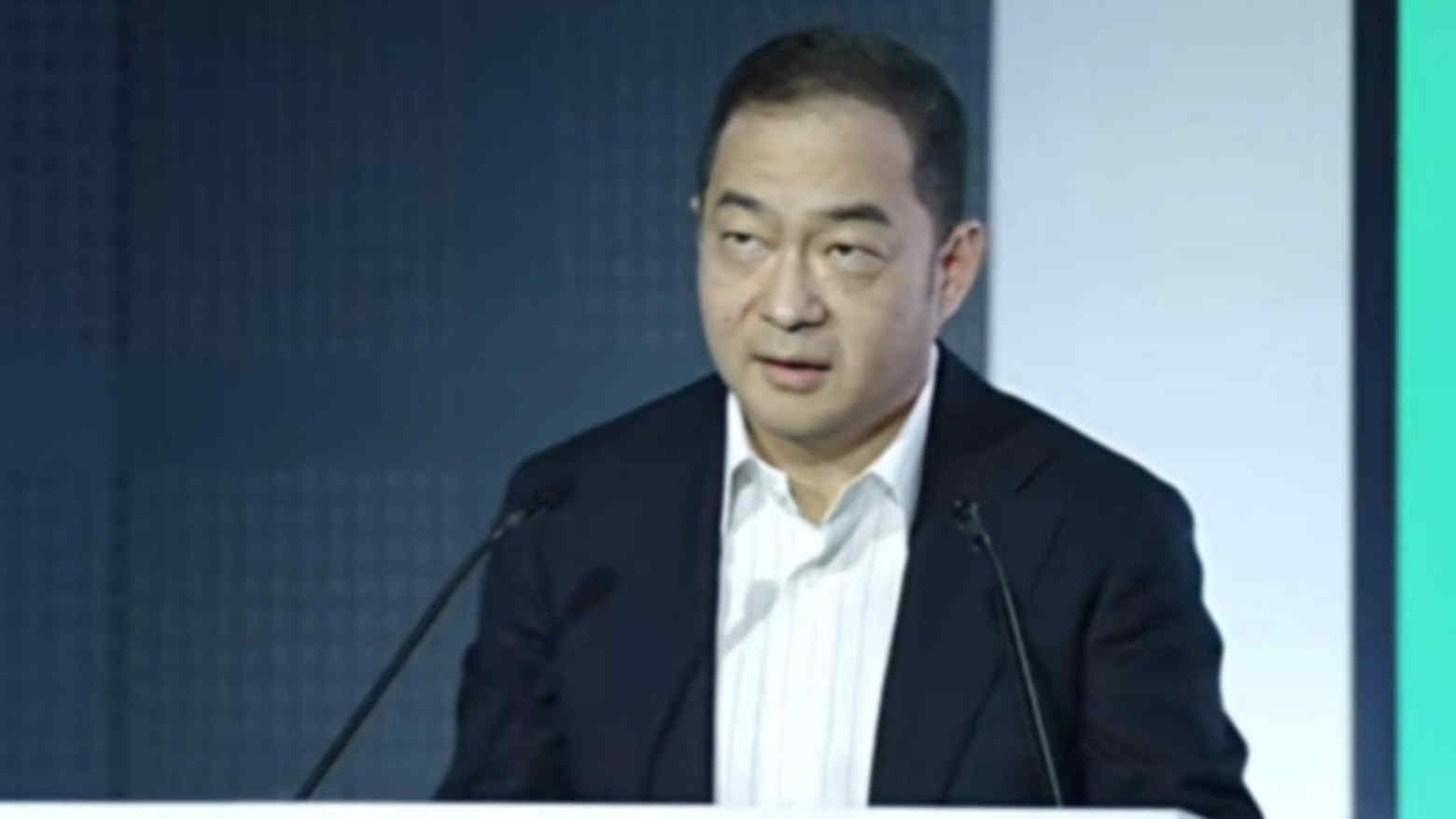 A senior executive speaks at a podium during a corporate event