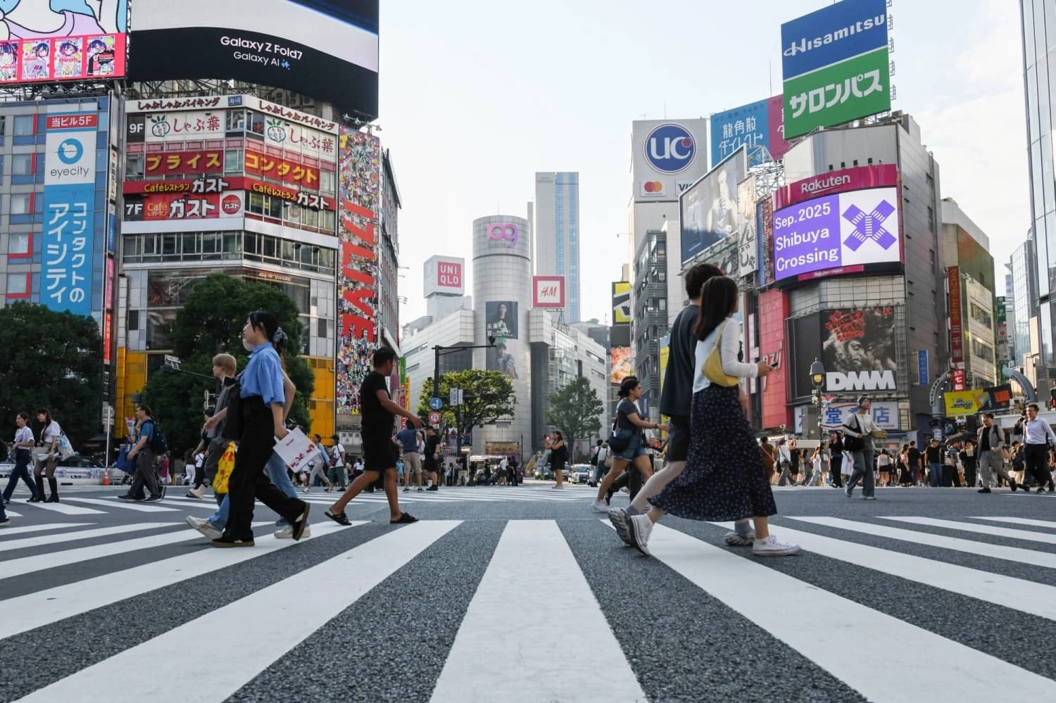Pedestrians cross the busy Shibuya intersection in Tokyo, Japan