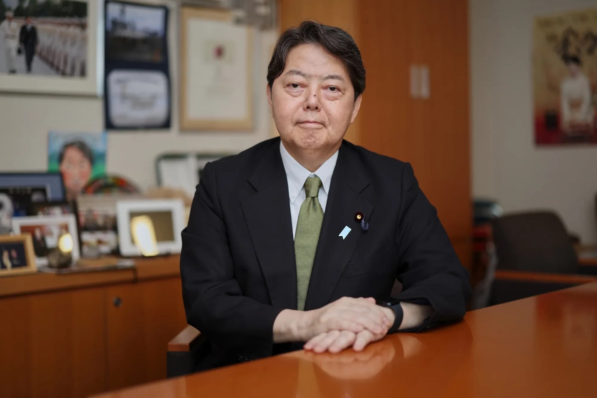 Yoshimasa Hayashi seated at a desk in his office with hands folded