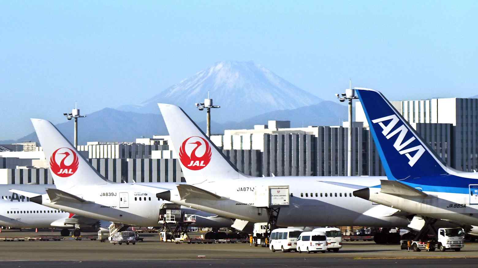 Japan Airlines and ANA aircraft parked at Haneda Airport in Tokyo with Mount Fuji in the background