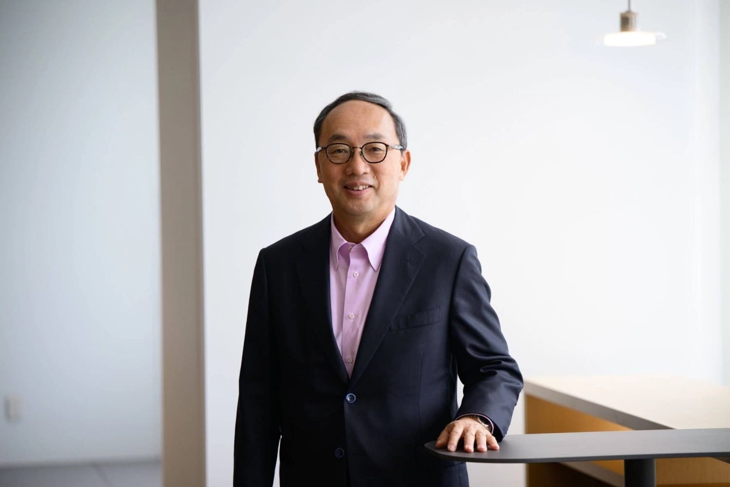 Mitsubishi Electric chief executive Kei Uruma standing beside a table in an office