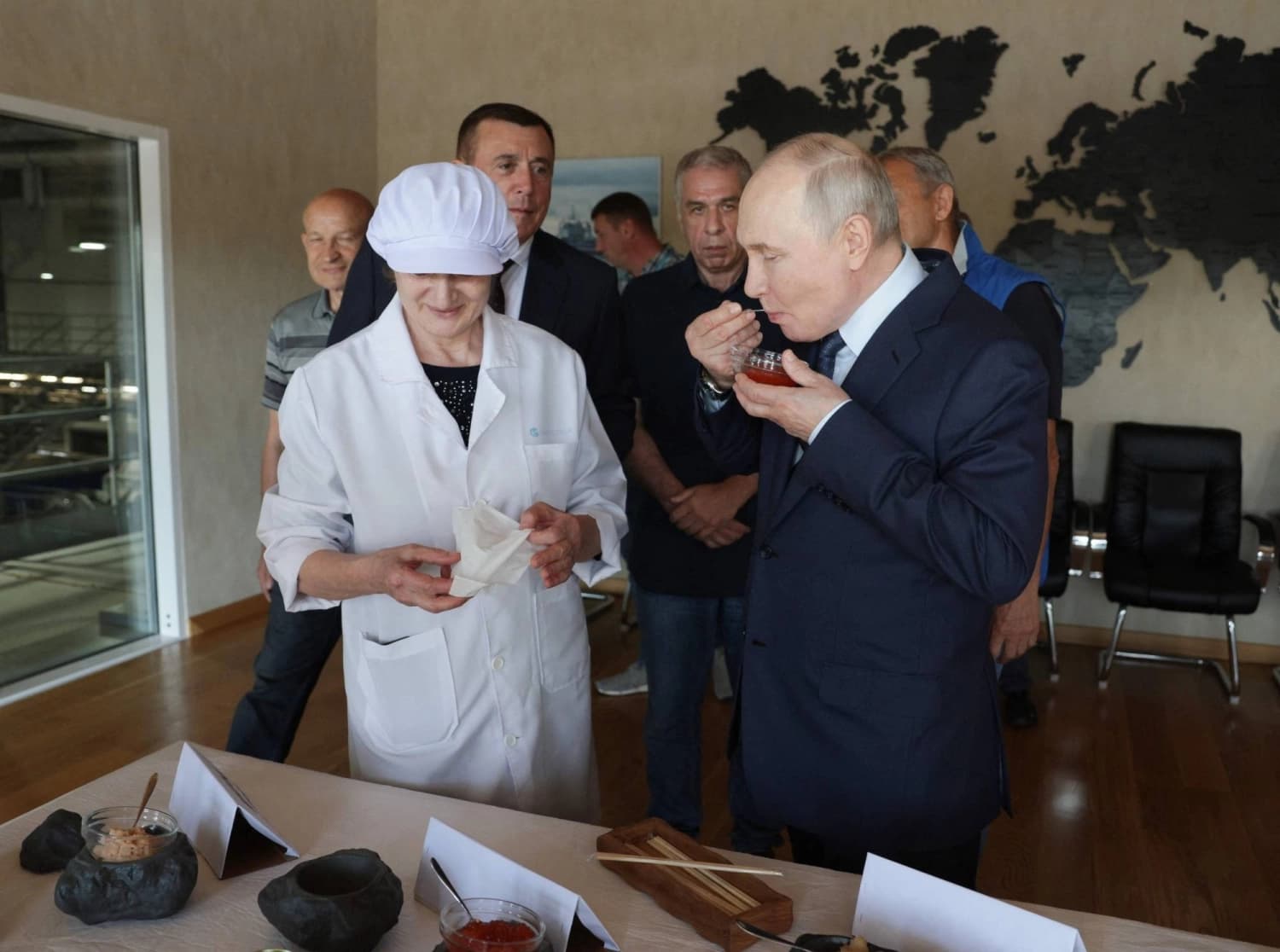 Russian President Vladimir Putin samples seafood at a fish processing plant during his visit to the disputed Kuril Islands
