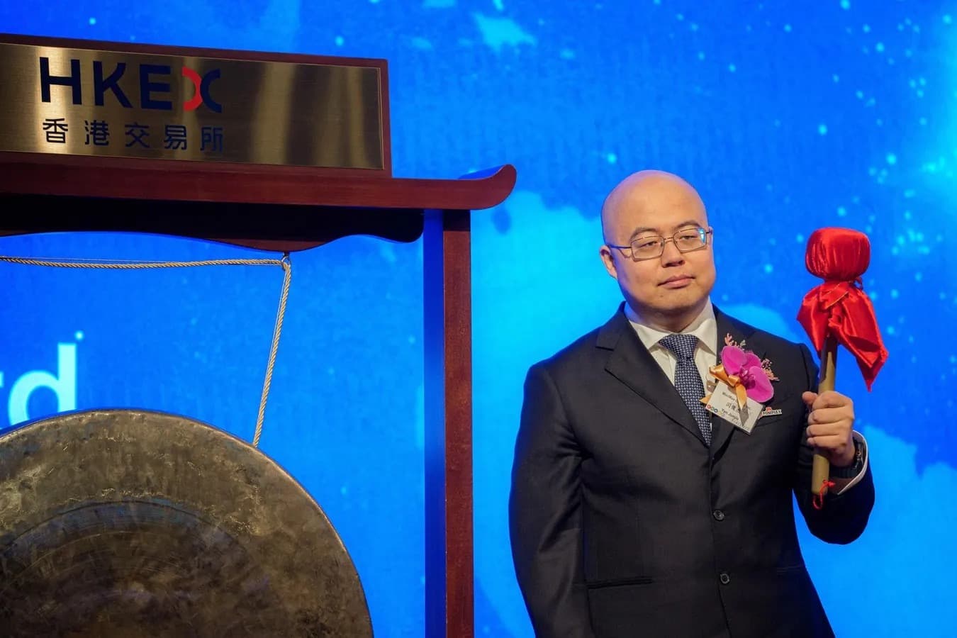 MiniMax chairman Yan Junjie holds a gong striker at the Hong Kong stock exchange listing